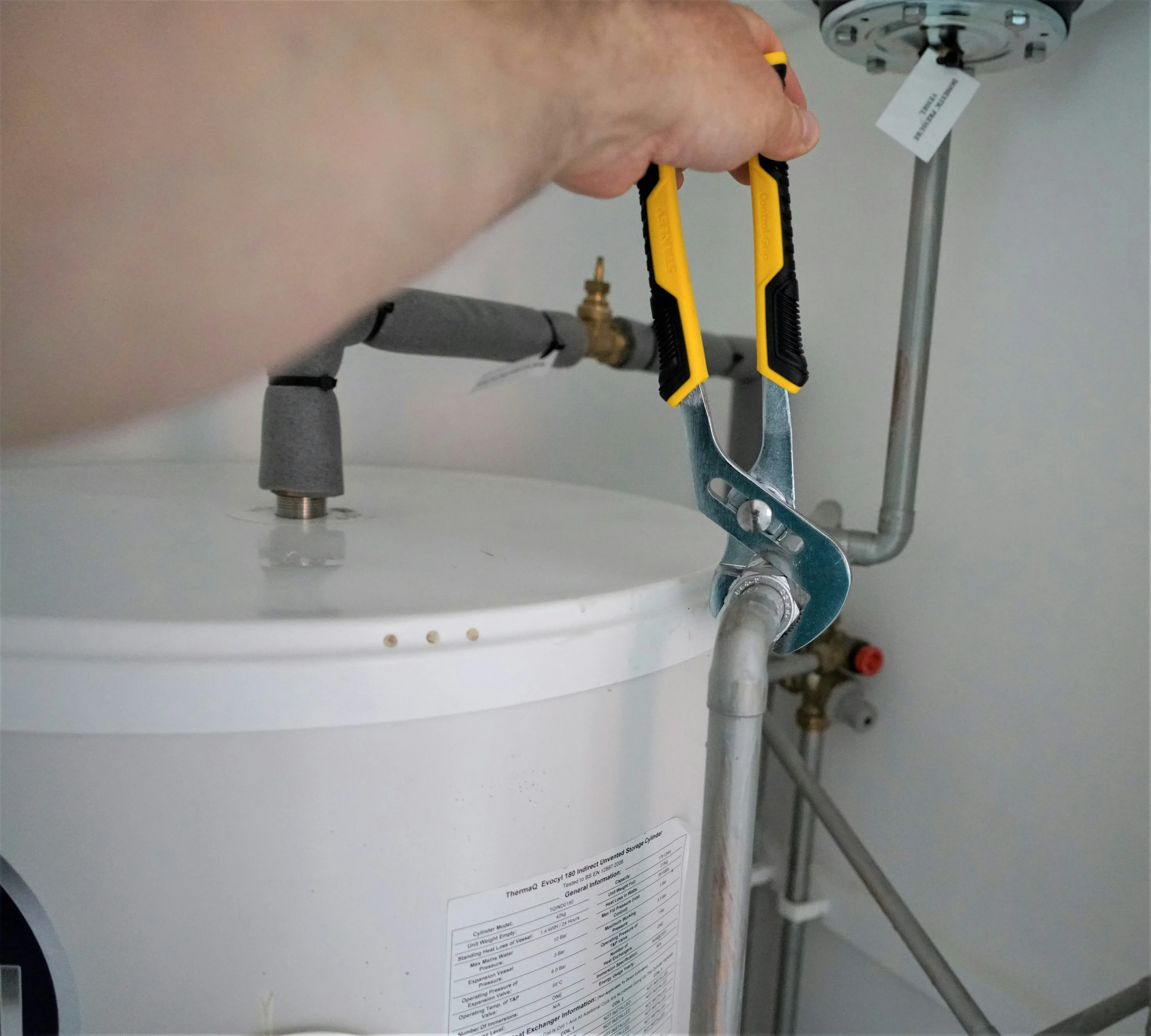 Technician working on the connections of a water heater tank