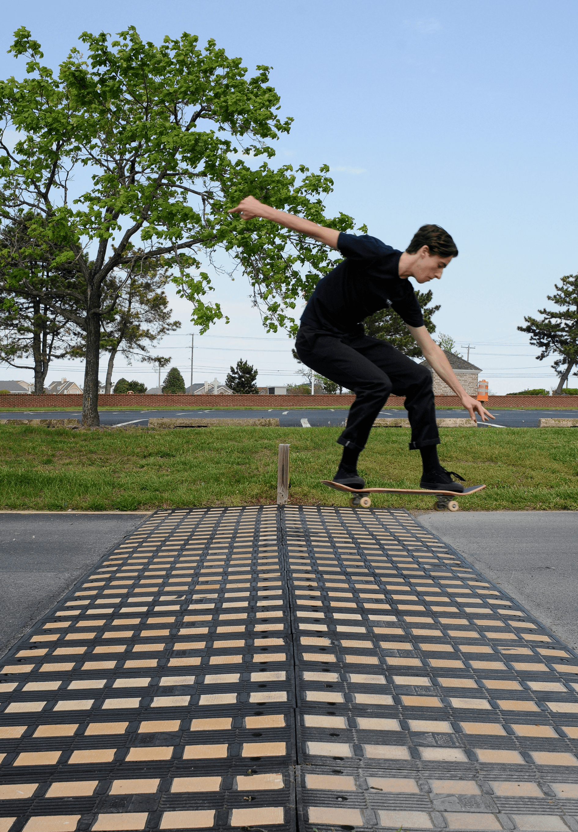 Digital photography of a skateboarder jumping over a large geometric speed bump