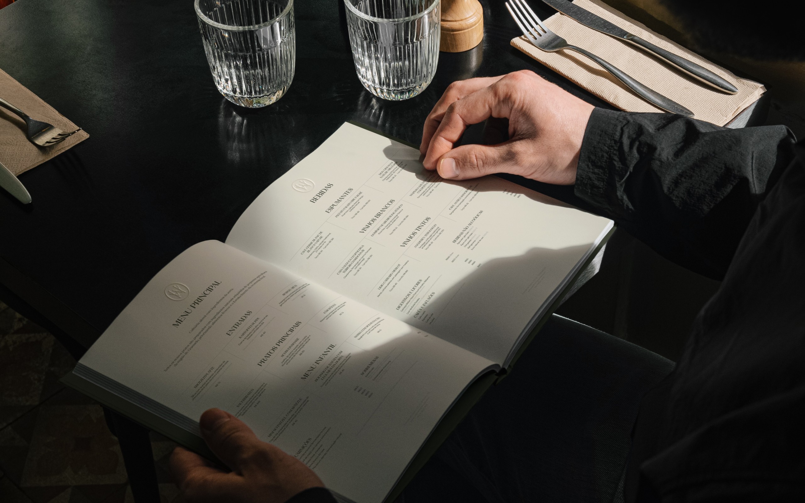 Pessoa folheando o menu impresso do restaurante Waldheim.