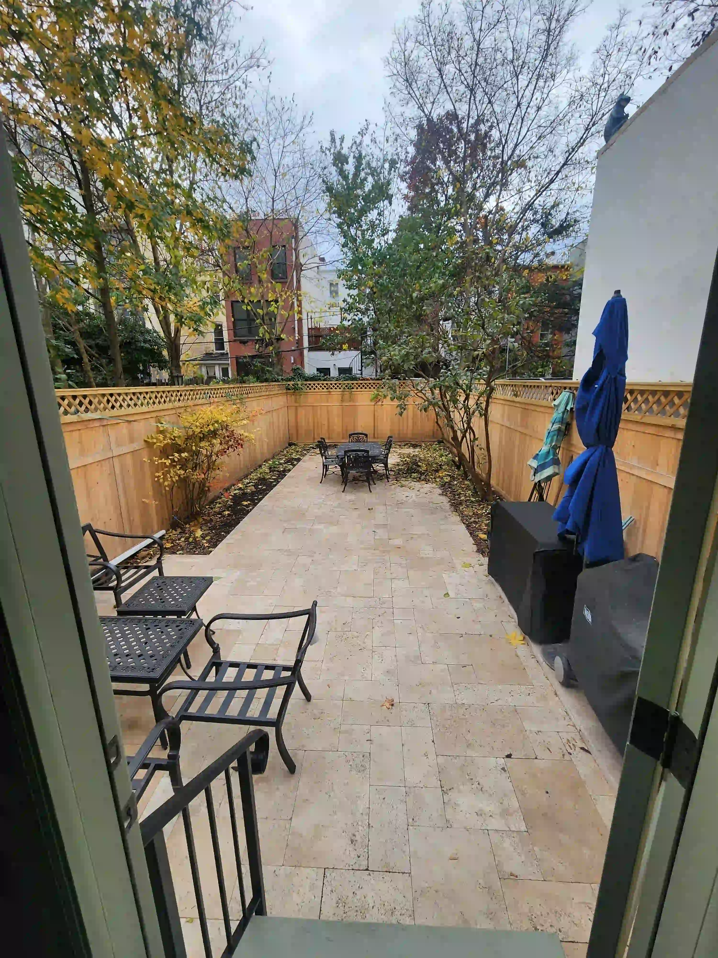 Custom cedar tongue-and-groove fence with Tuscany Beige tumbled travertine pavers in Park Slope Brooklyn by Jewel Construction