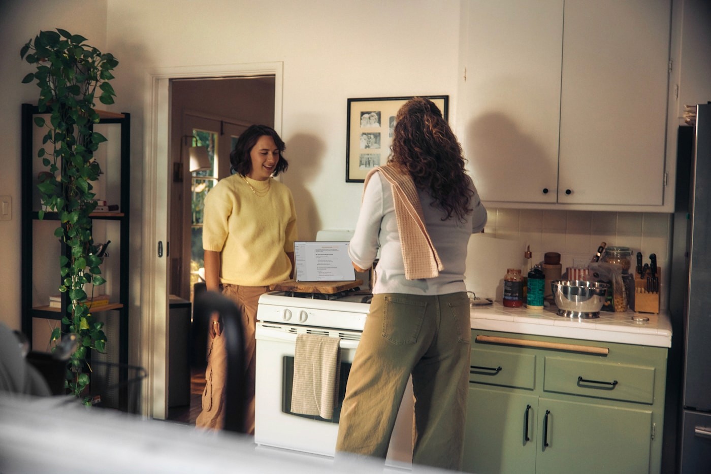 A supportive conversation between two women in a home kitchen, reflecting personalized postpartum nutrition support with a dietitian