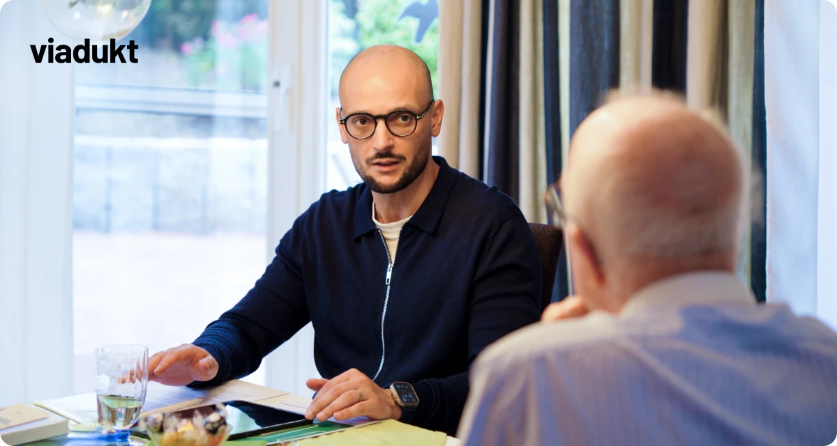 Energieberatungsgespräch mit Herr Salihu auf dem Tisch liegen Tablet mit viadukt Gebäudeassistent und Materialien zur Beratung wie Energiebedarfsausweis