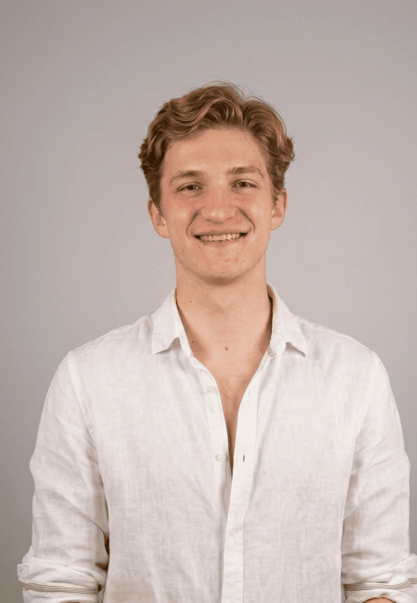 Portrait of a laughing person with curly hair wearing a white shirt