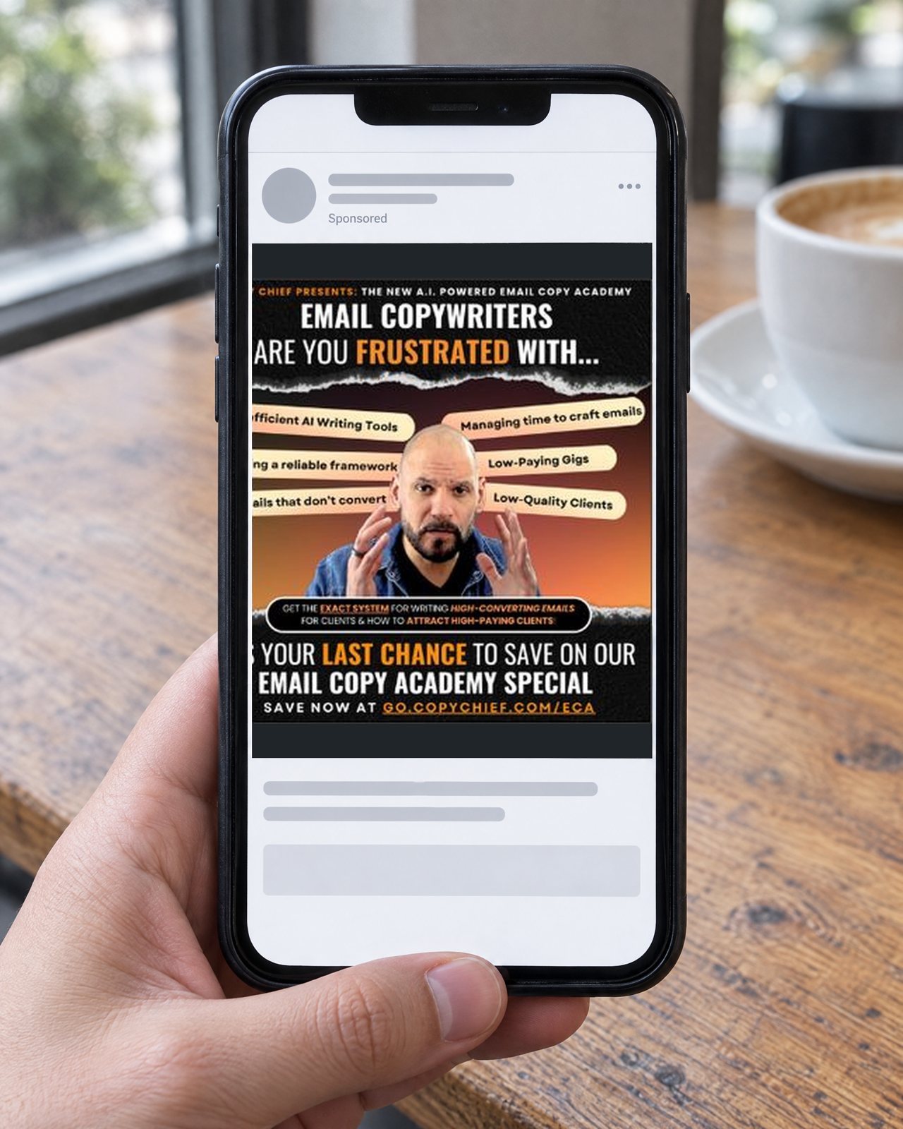 A phone in a cafe showing the real Email Copy Academy Meta ad for Copy Chief, Email copywriters, are you frustrated with...