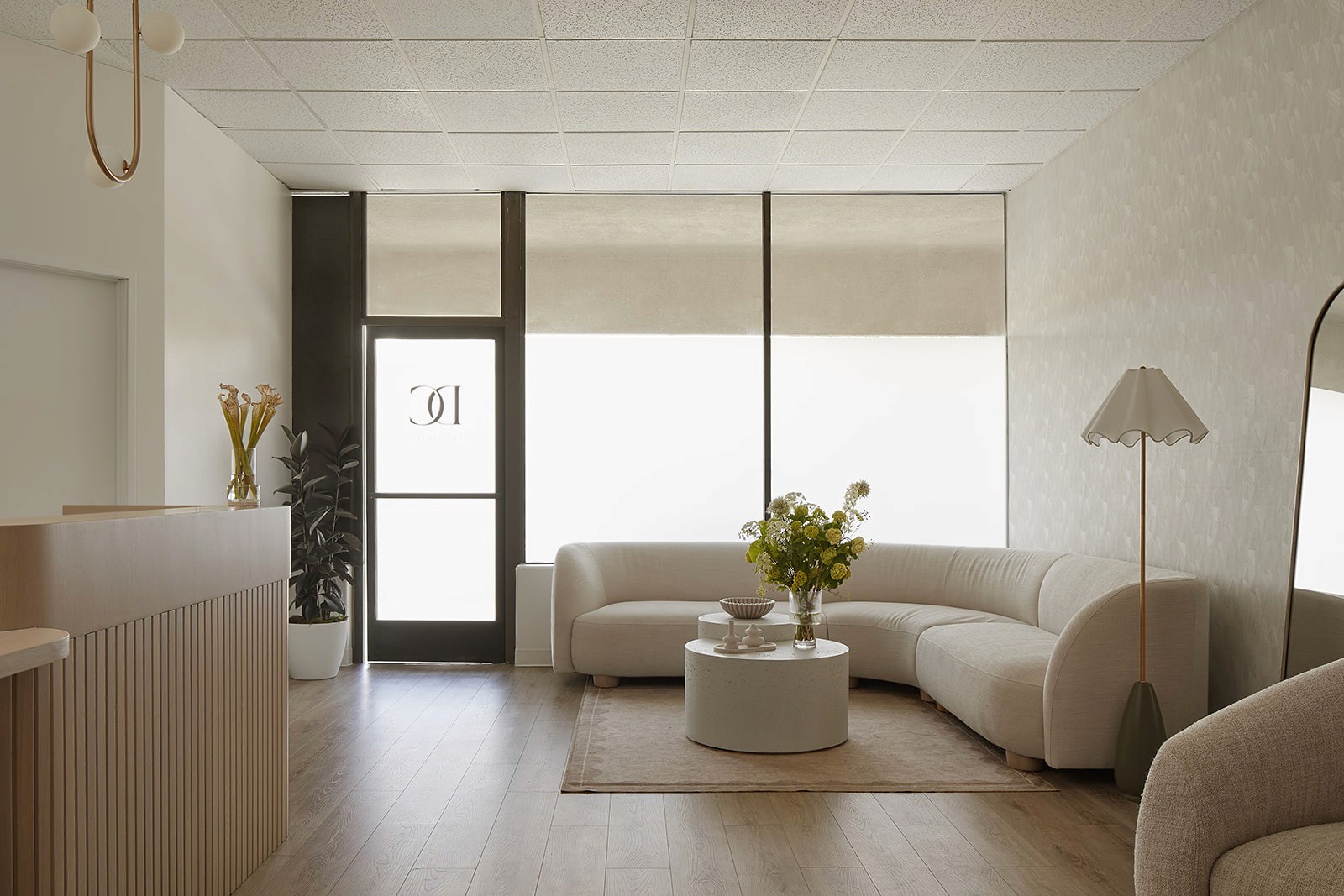 DC Dermatology waiting area featuring curved seating, soft neutral finishes, and natural light flowing through frosted entry doors.