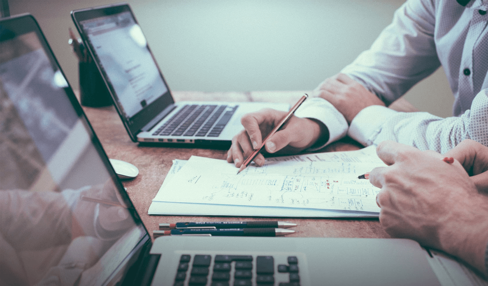 People collaborating over documents and laptops - UX Research Report