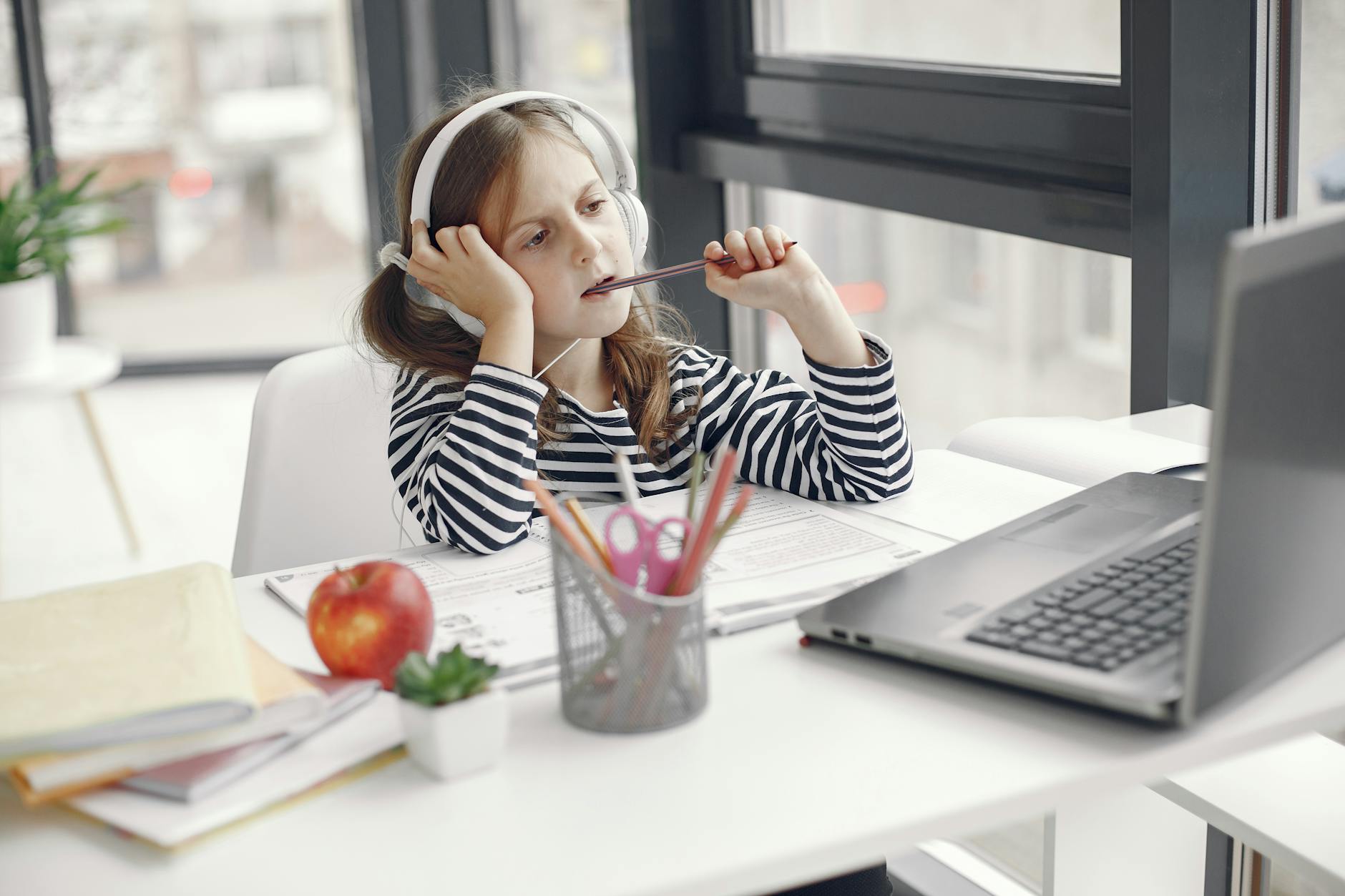 Close-up of a student carefully plugging a tablet into a charging station in a modern media center.