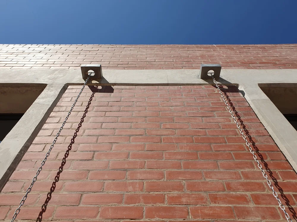 Black and white photo of tall city skyscrapers with birds flying between them.