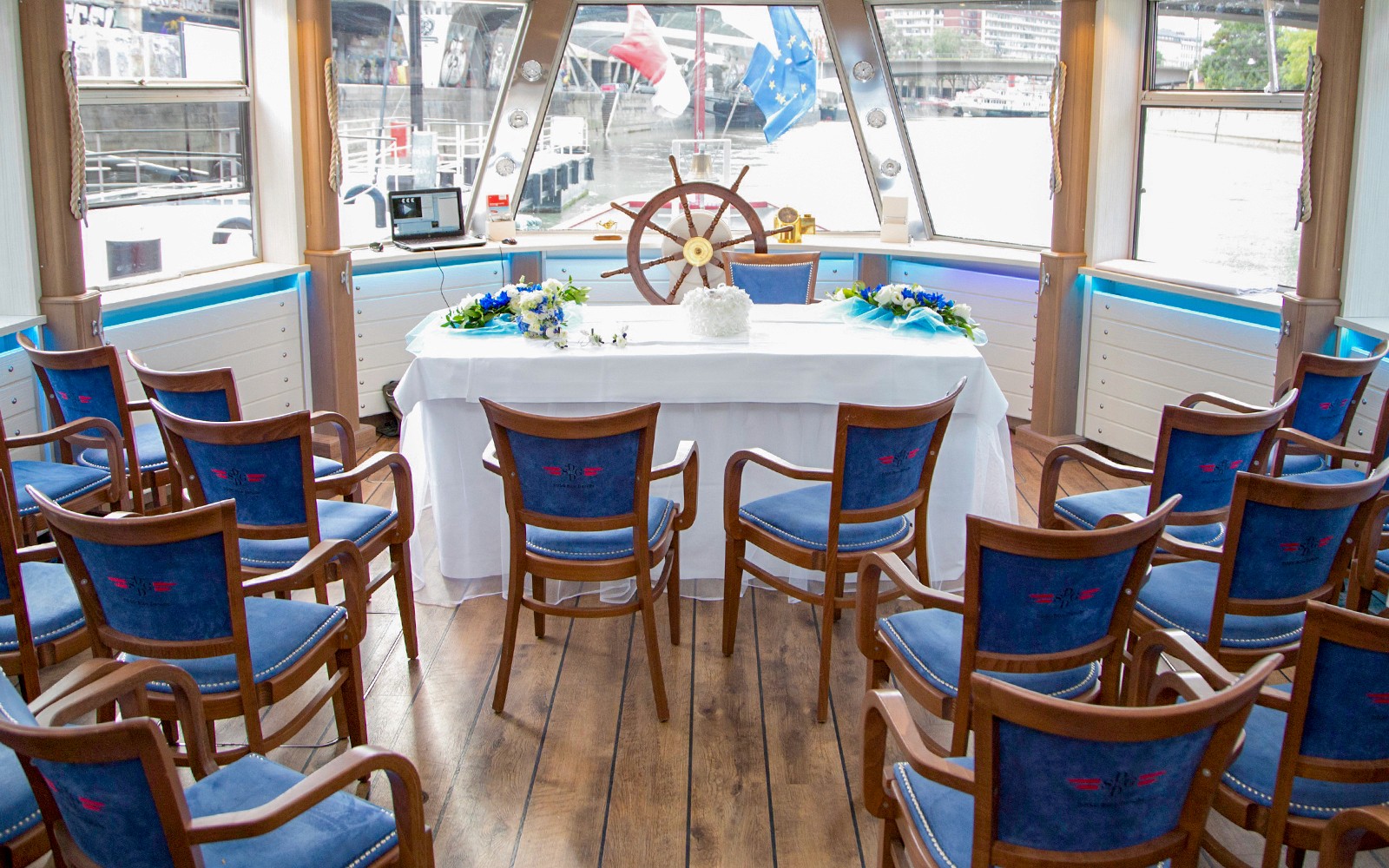 Interior kapal pesiar Kanal Danube dengan tempat duduk yang tertata rapi dan meja yang dihiasi dengan dekorasi.