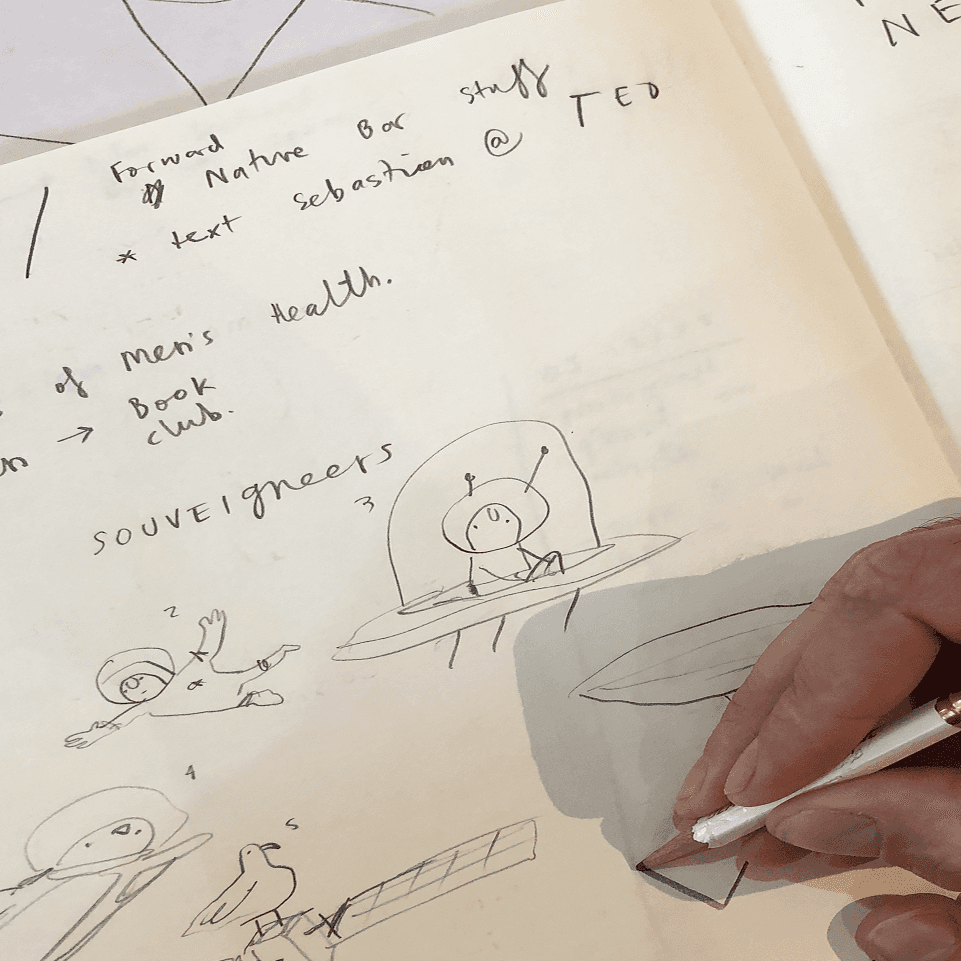 Close-up of hands arranging yellow sticky notes during a design workshop session.