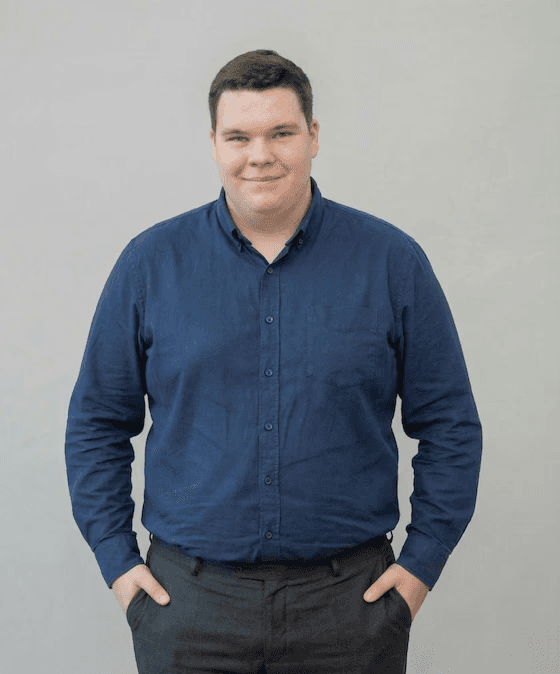Portrait of a person in a pink sweater against a light background