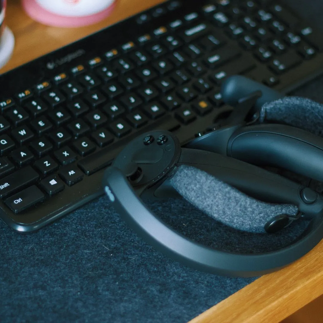 Close-up of a keyboard and VR headset resting on a desk
