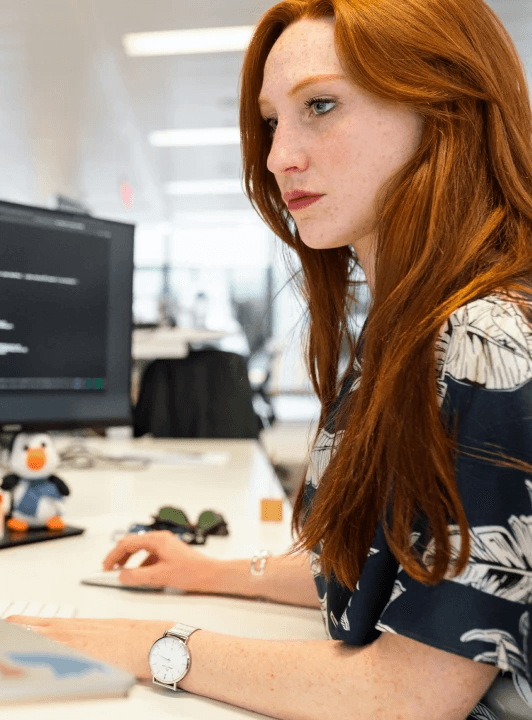 female software developer coding at her office computer