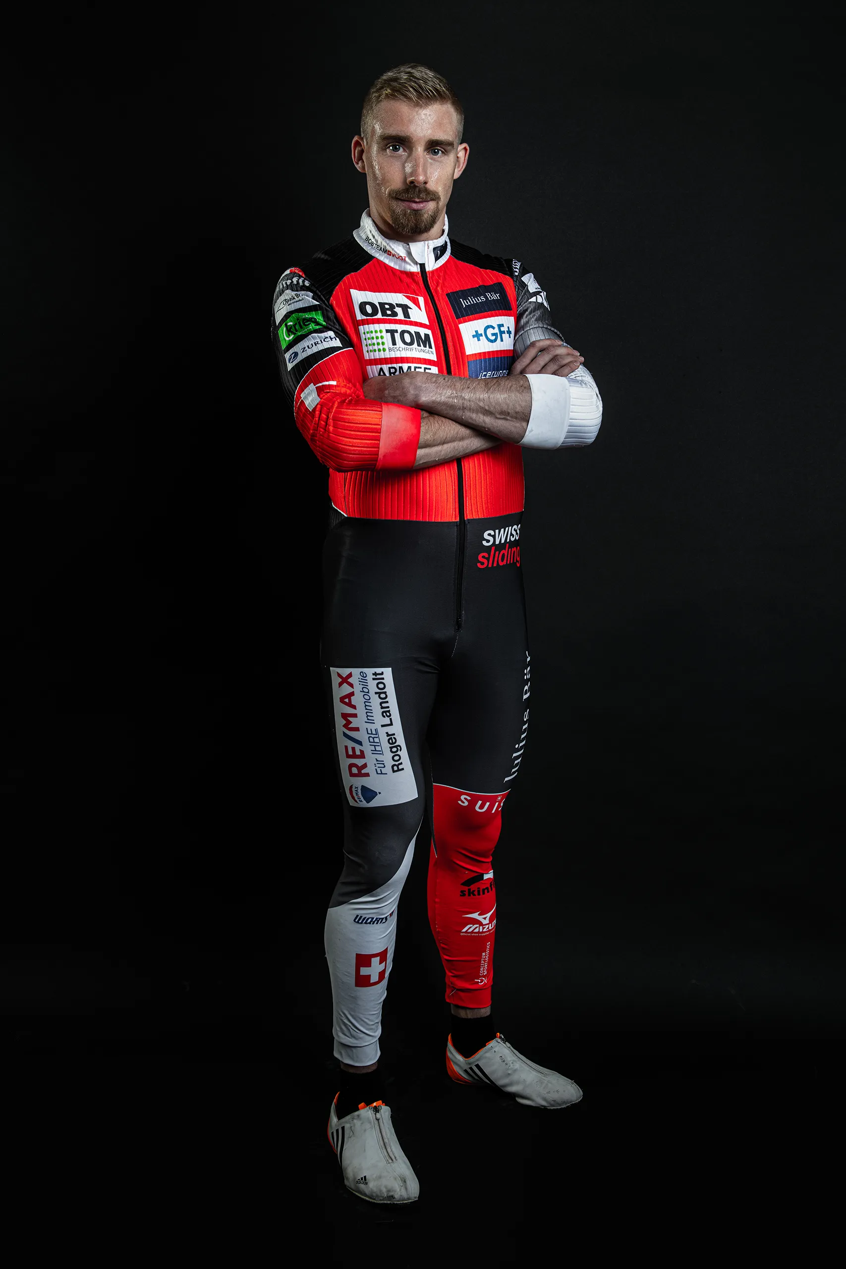 Dark background studio portrait of a Bobteam Vogt athlete in full racing uniform