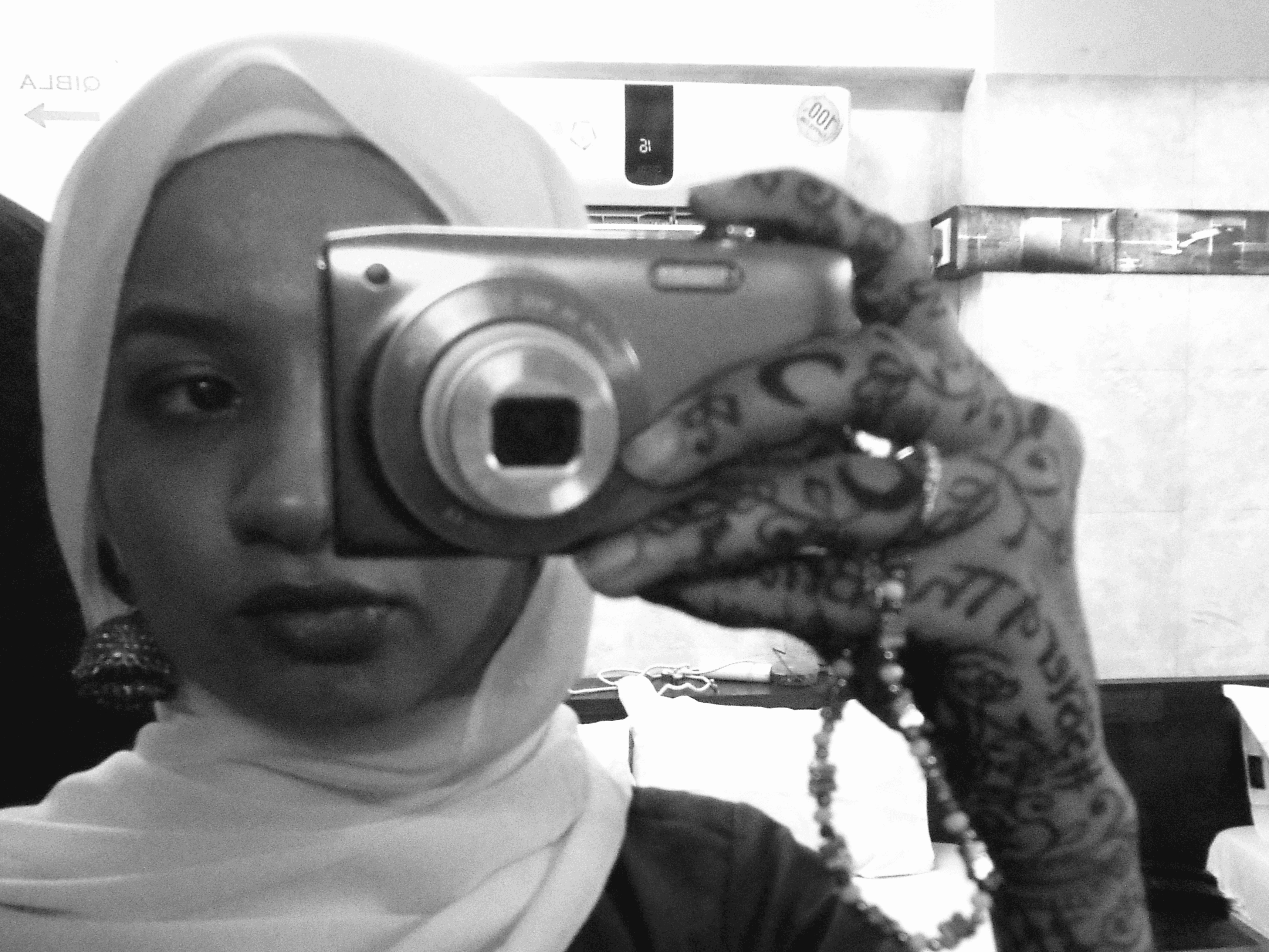 A thoughtful young person with dark hair gazes to the side, captured in soft black and white lighting.