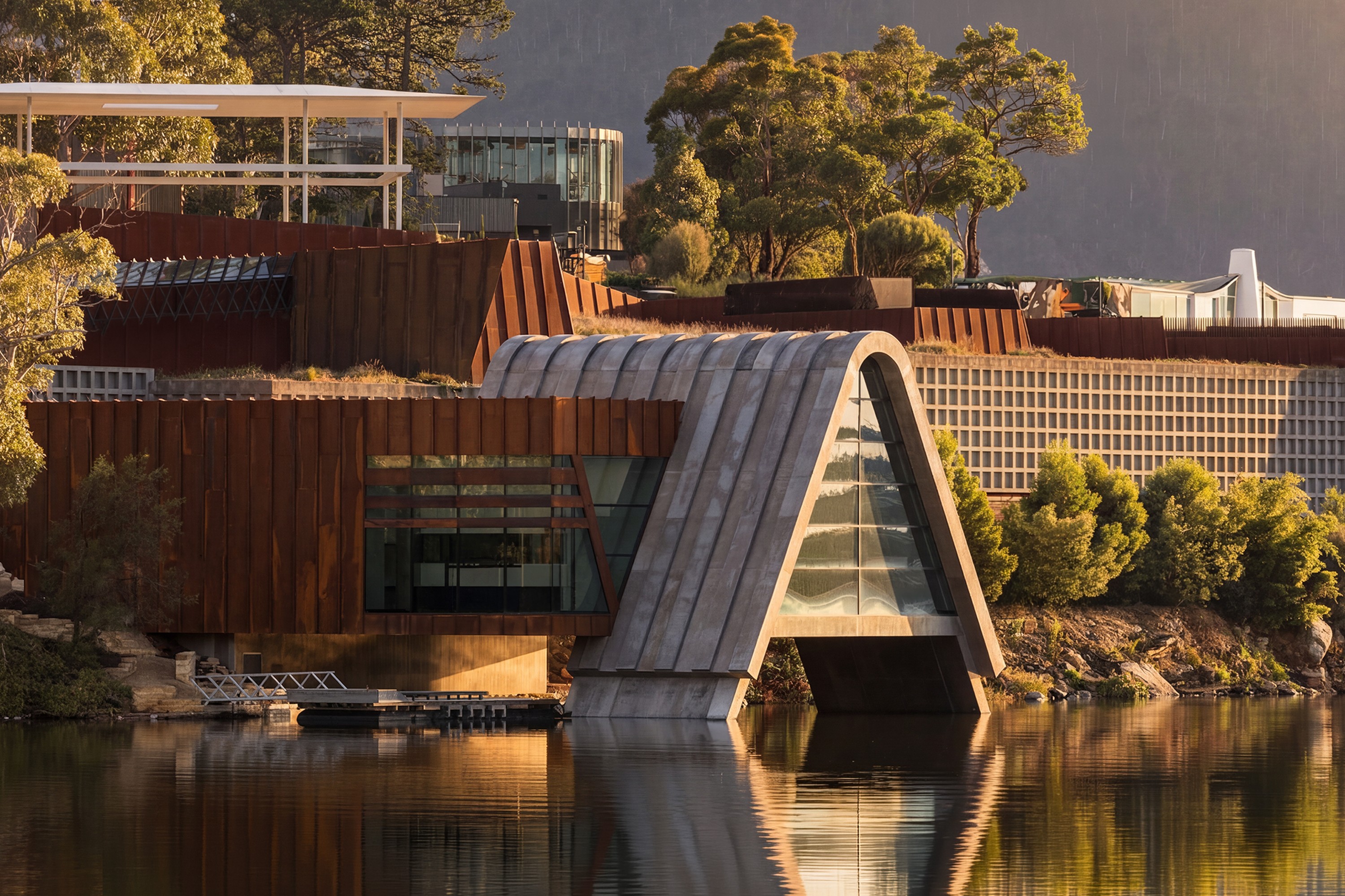 The Museum of Old and New Art (MONA) sits strikingly along the Derwent River, where rusted Corten steel meets bold concrete geometry. This hero shot captures the industrial, fortress-like exterior that defines Hobart’s iconic subterranean gallery.