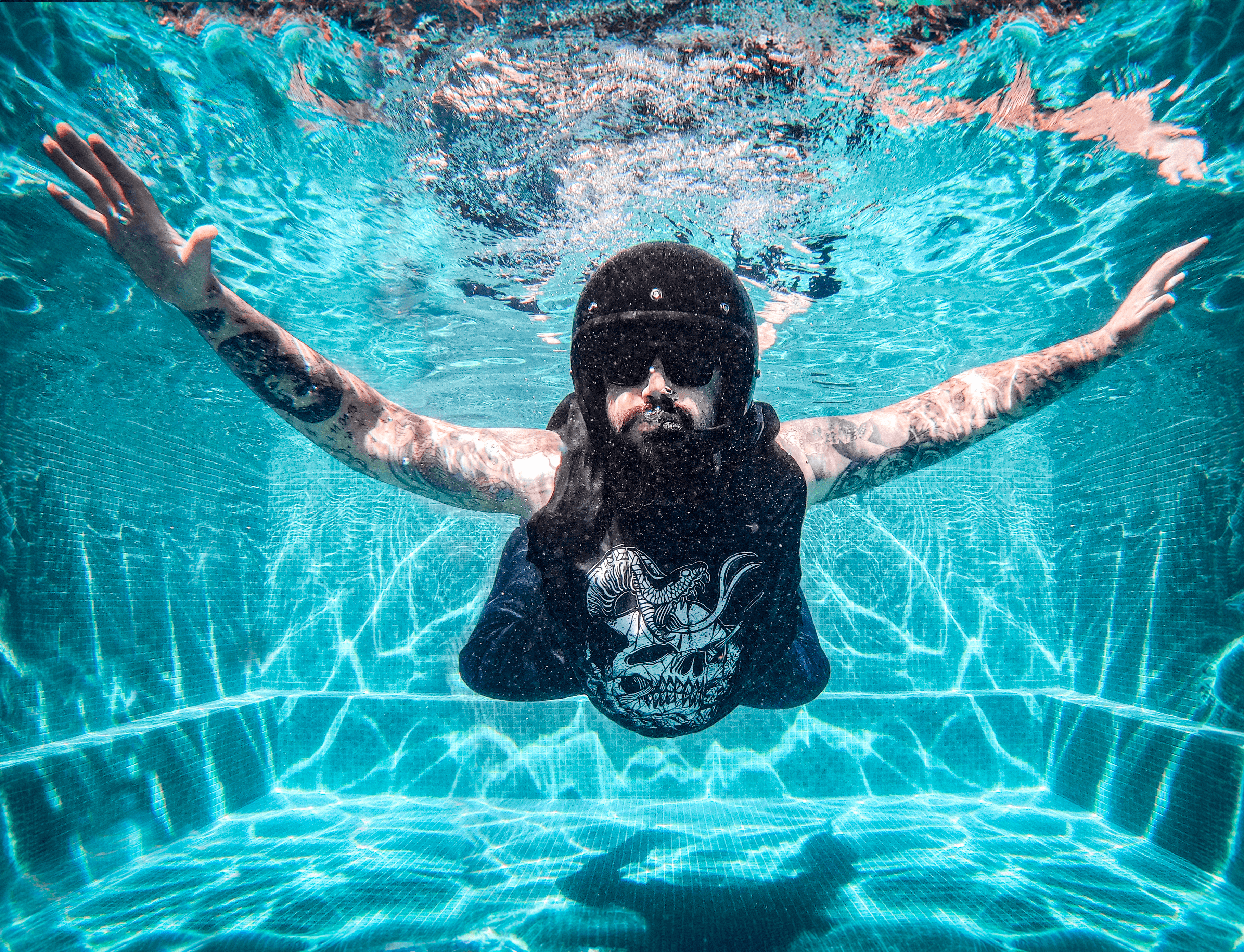 man in motorcycle helmet diving into pool