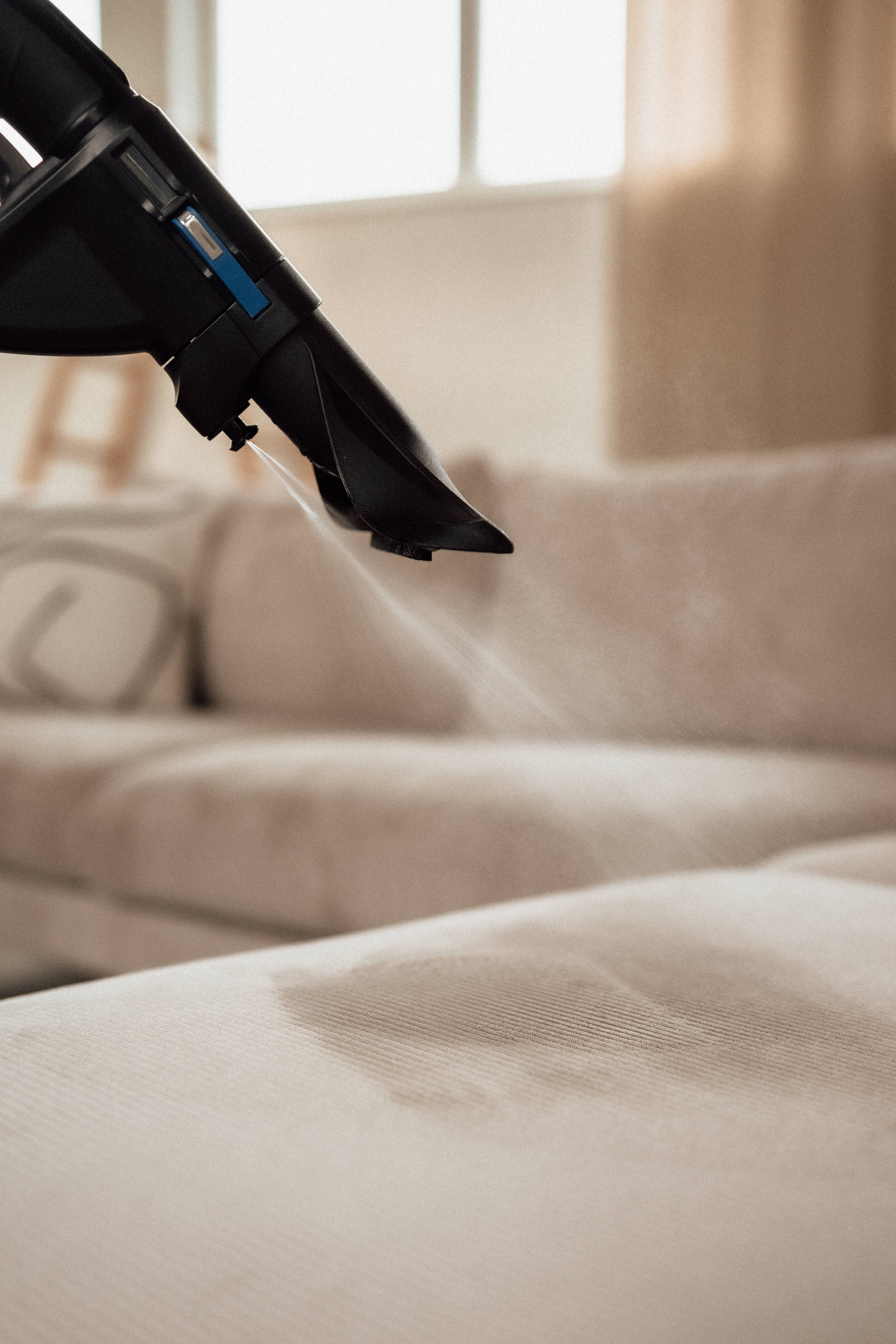 eine Frau, die mit dem HYLA eine Polsterreinigung durchführt