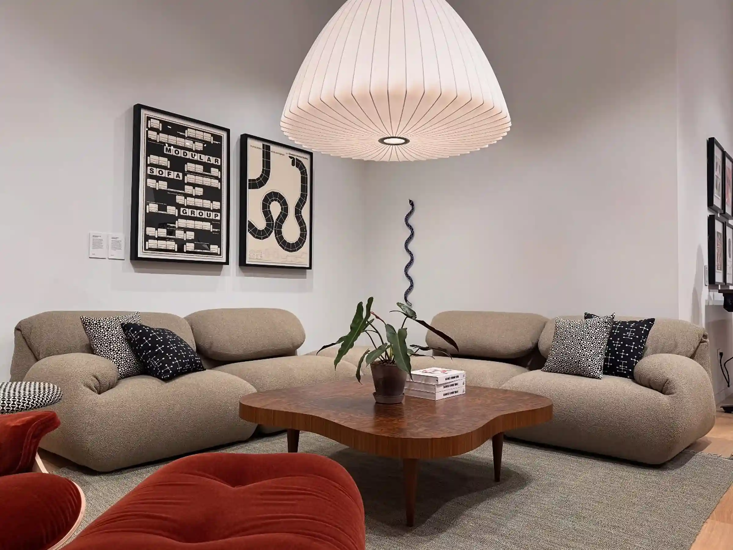 Hardwood flooring in an upscale Herman Miller furniture showroom lounge with curved modular sofas, organic coffee table, and pendant lighting.