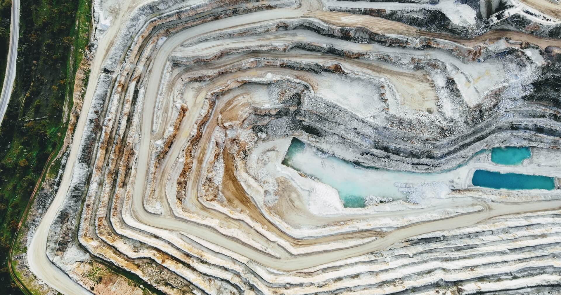 Aerial view of an open-pit mine, showcasing the cut terrain and mining activities