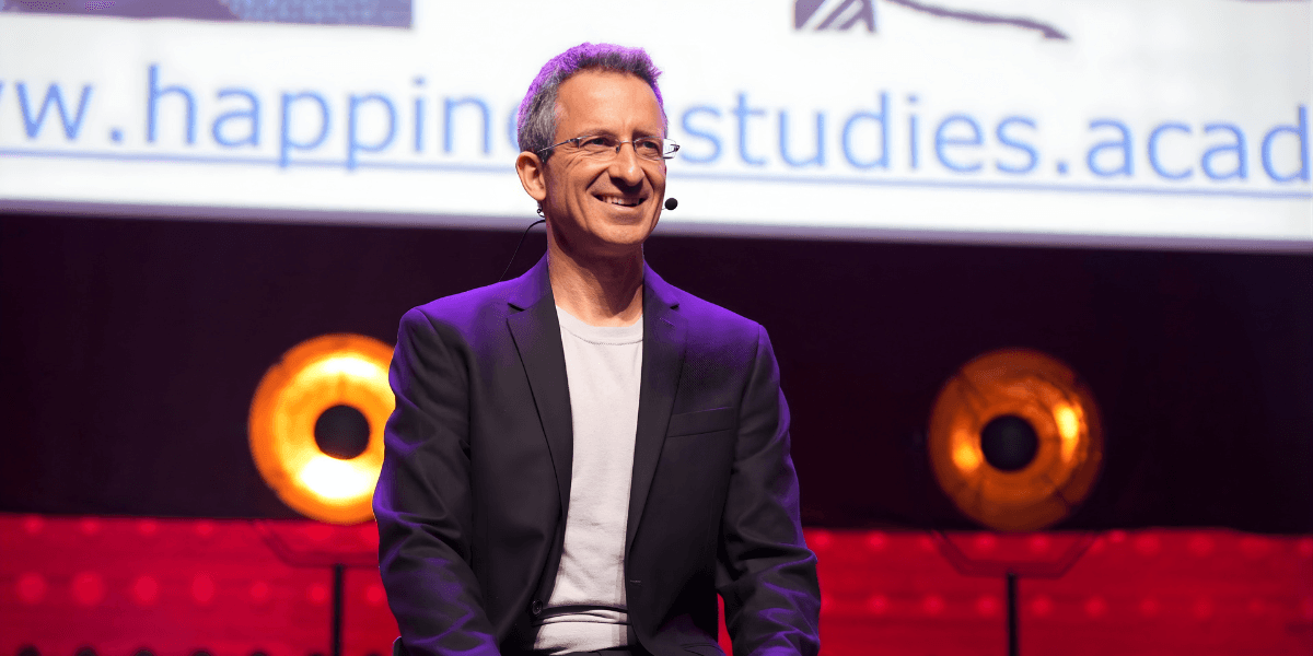 Dr. Tal Ben-Shahar, founder of the Happiness Studies Academy, speaking on stage about the SPIRE model for organizational wellbeing.