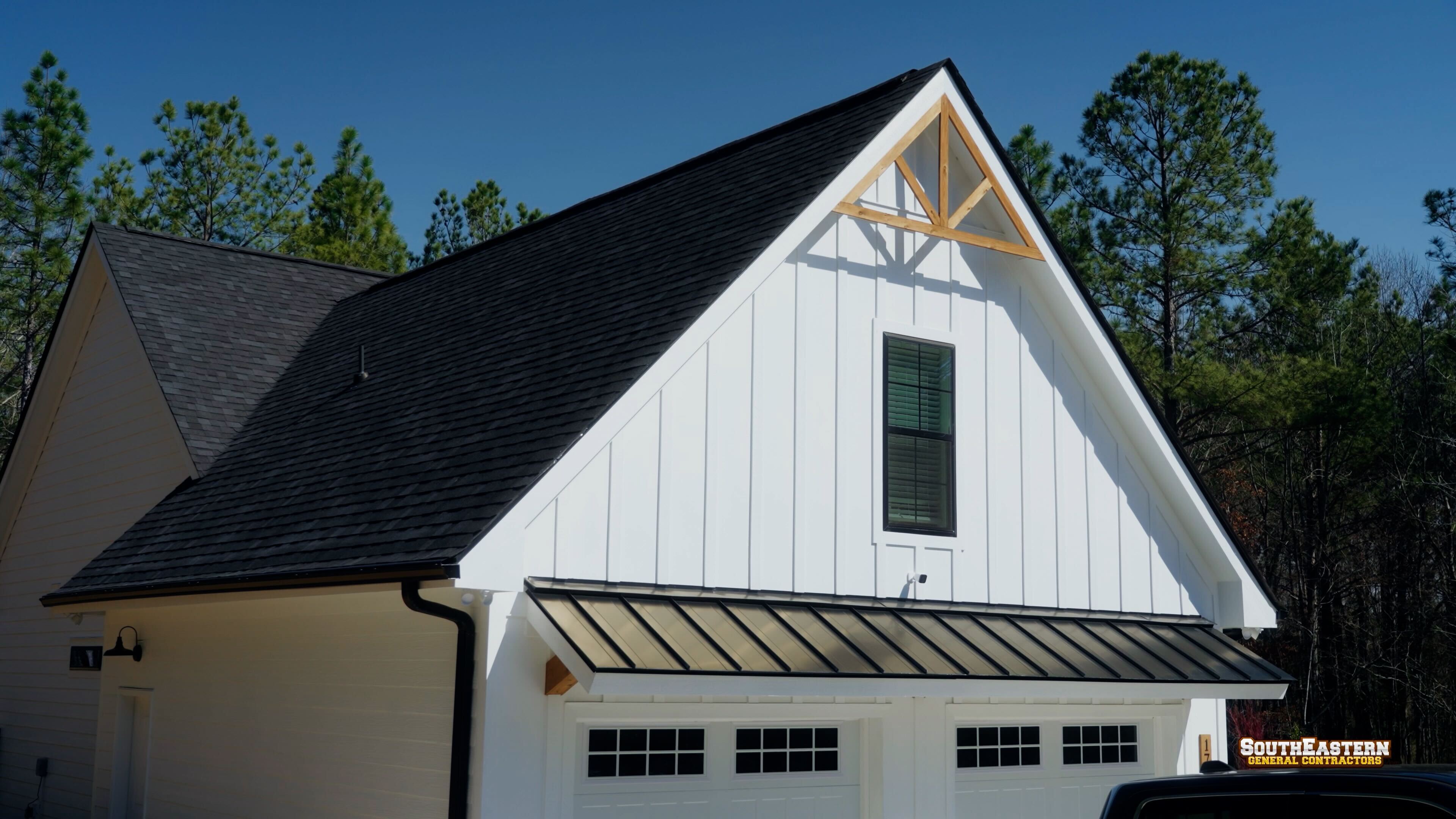 Completed custom home exterior with standing seam metal accent roof and board-and-batten siding built by South Eastern General Contractors