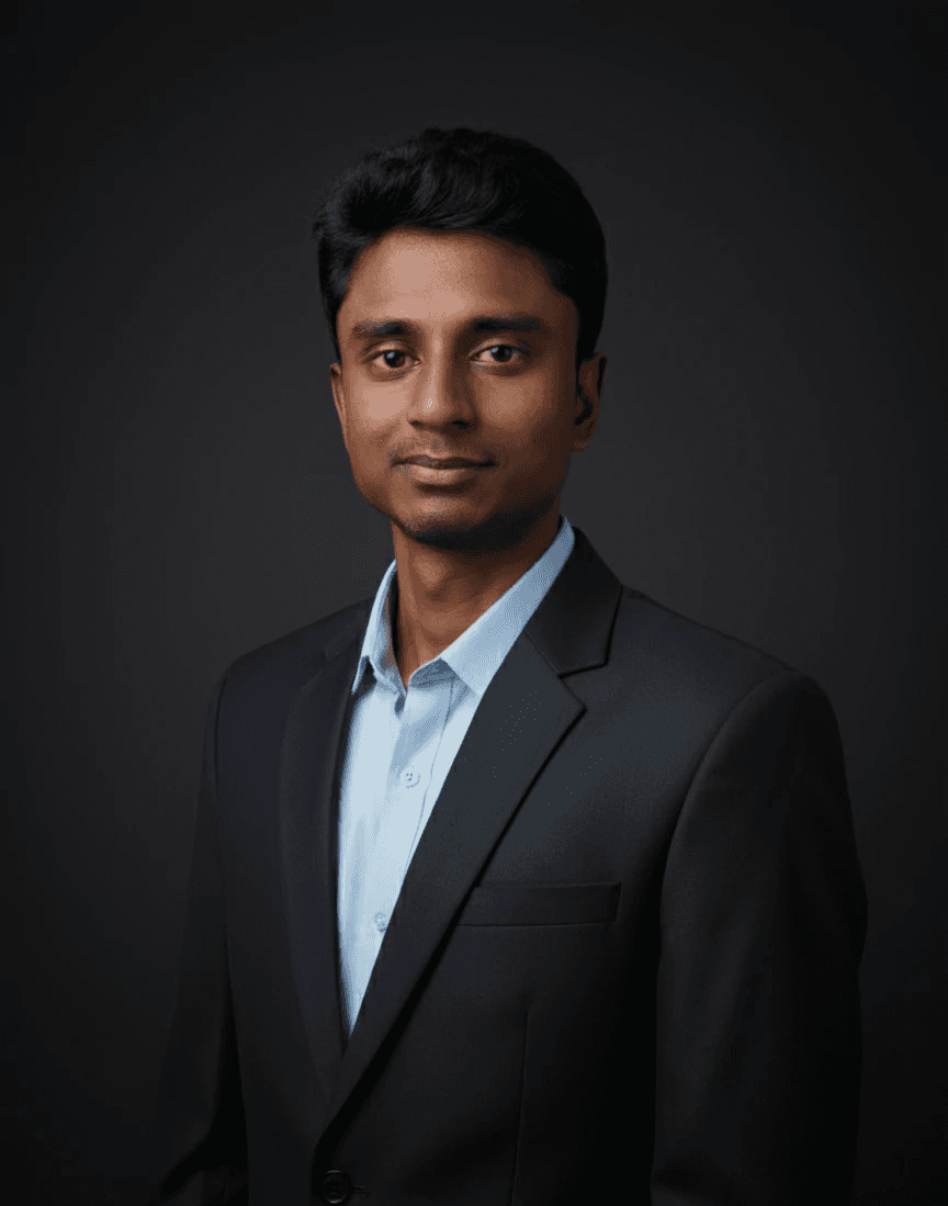 Business professional in a dark suit and light blue shirt posing against a dark background.