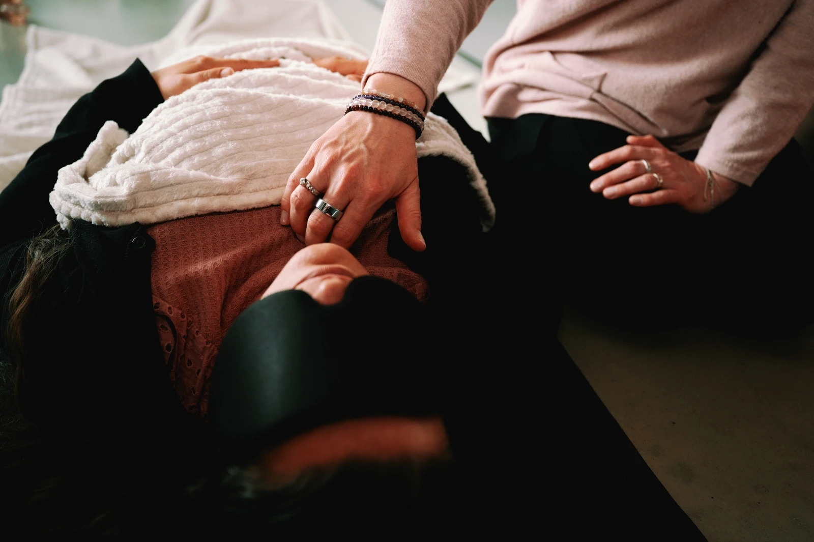 Hiker walking along a narrow mountain ridge at sunrise, surrounded by misty rolling hills.