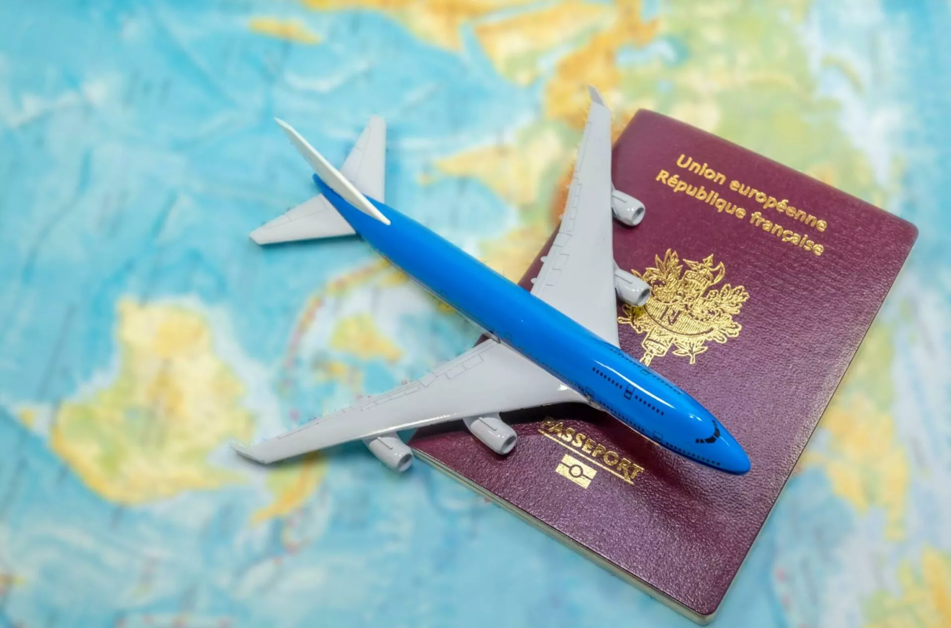 french passport on a worldmap with a plane