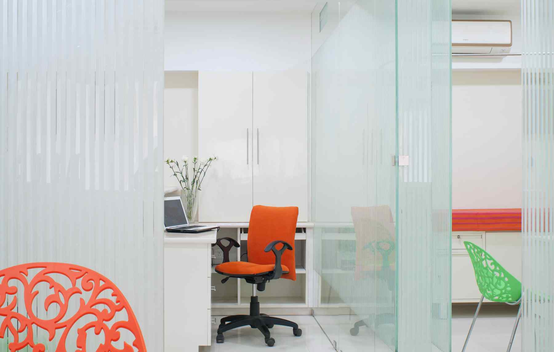 Nature-inspired preschool entrance with sculptural tree partitions and suspended green leaf ceiling panels.
