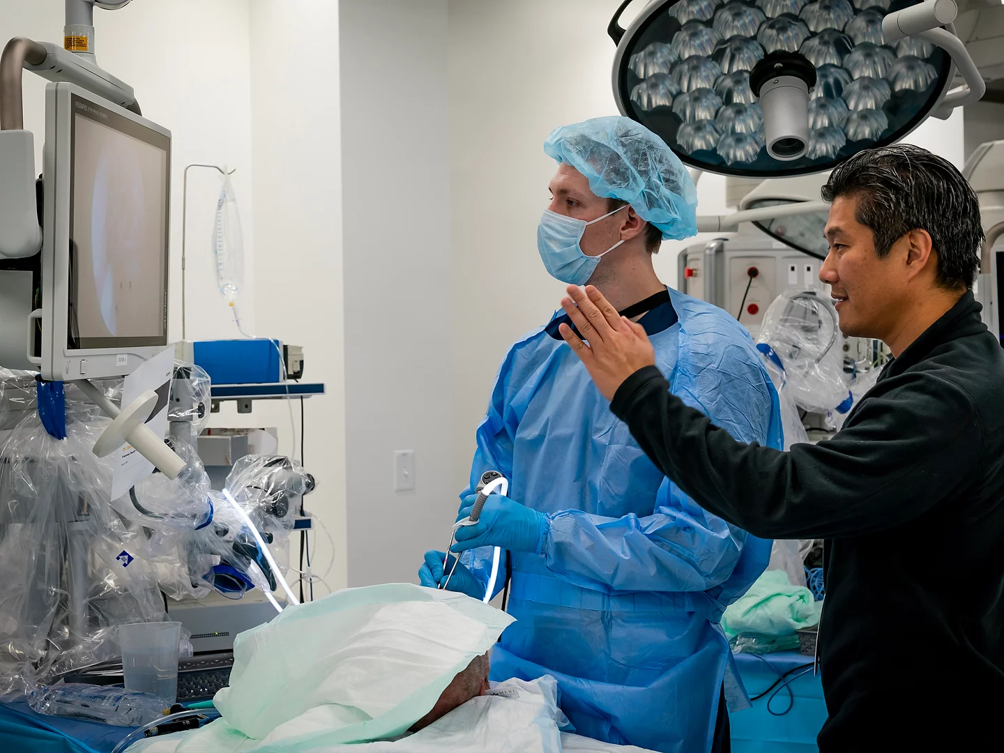 Red trolley car driving down a tree-lined street.