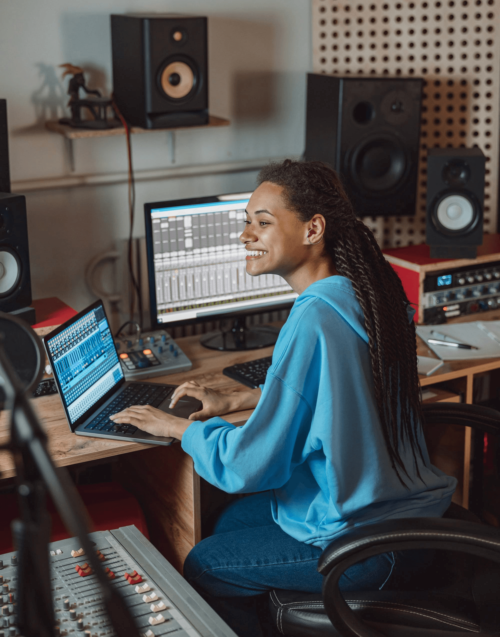 Three athletes resting on a blue running track; one lying on his back and two sitting nearby.