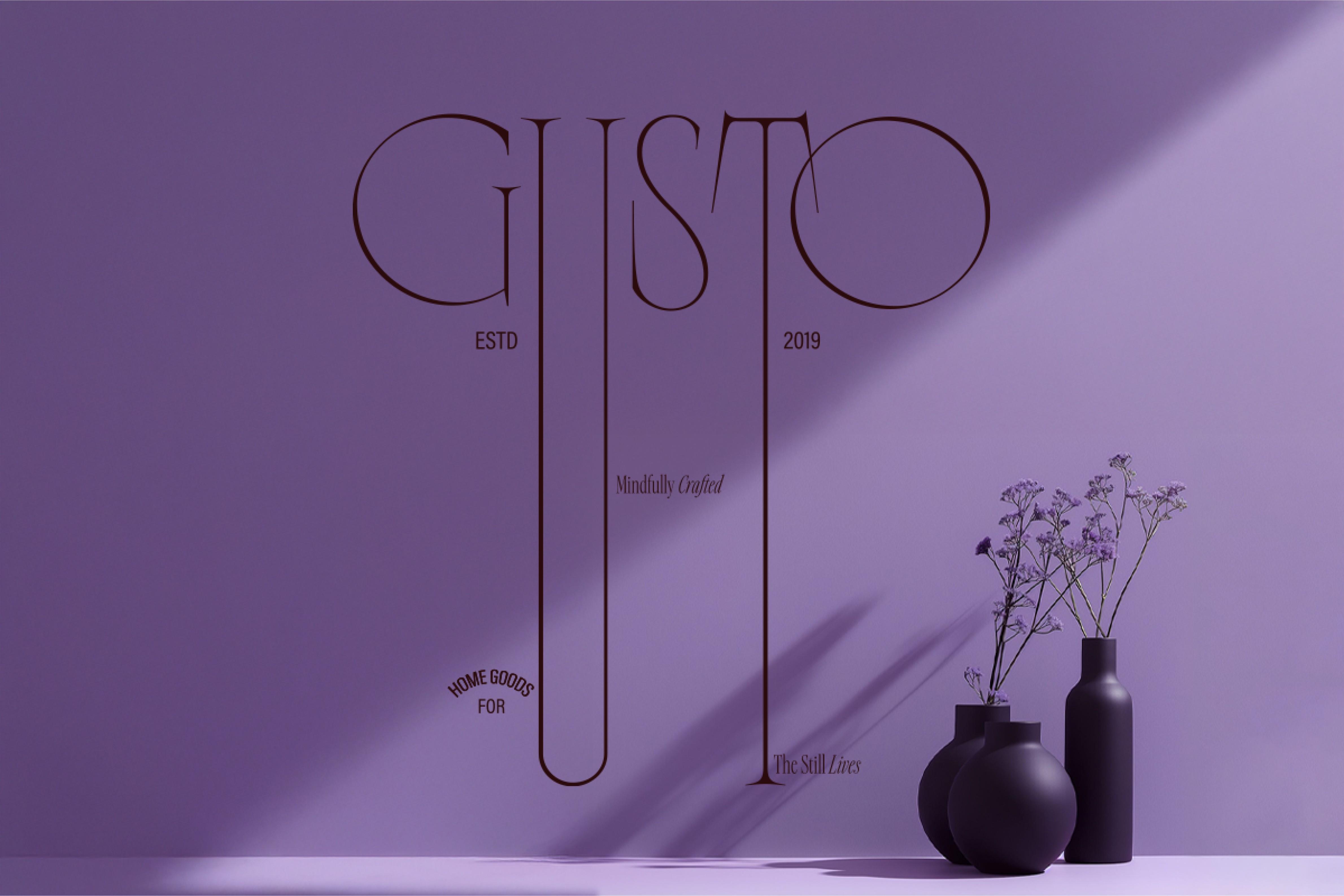 Minimalist Gusto logo displayed on a purple-toned wall with elegant pottery arrangements, reflecting the brand’s refined aesthetic and mindful craftsmanship.