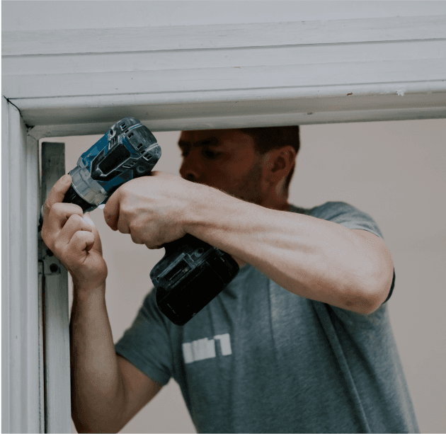 Professional drilling a door handle.