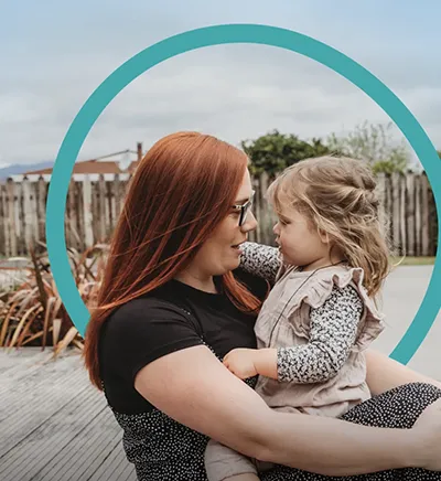 Close-up of a yellow tennis ball sitting on a green court, positioned near the white center line.
