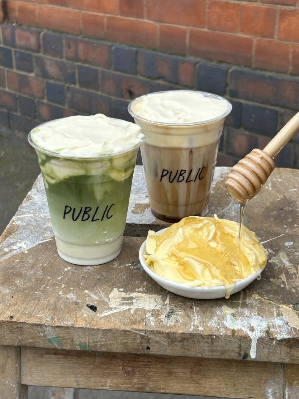 Two takeaway coffees served in Public branded cups