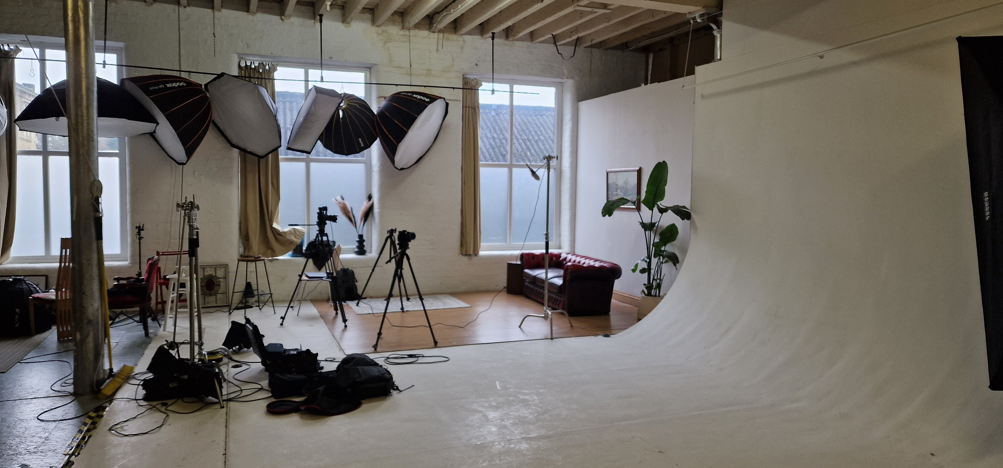 A studio that is partly setup with cameras, lights and equipment. 