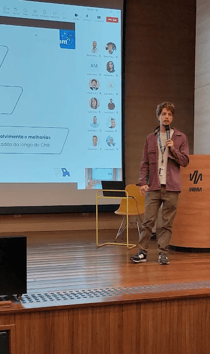 Leonardo palestrando sobre um produto digital com um microfone na mão e em cima de um palco