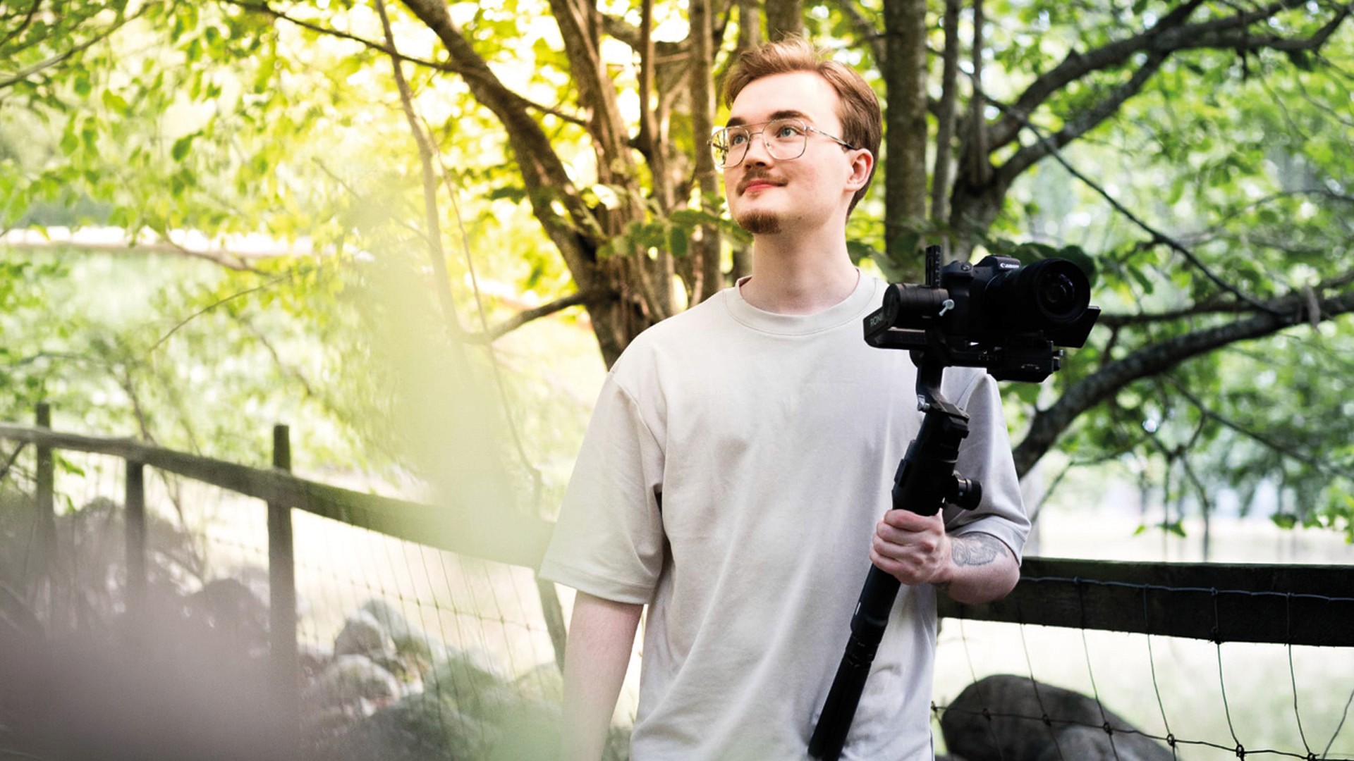 Fotograf går med sin kamera i handen.