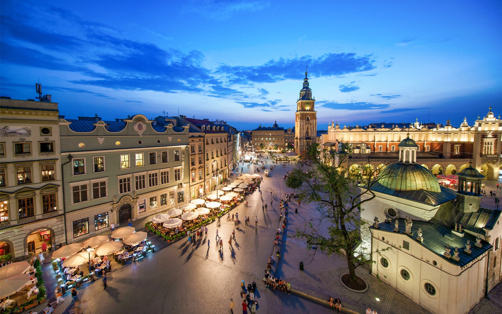 De Grote Markt van Krakau in de schemering met de Mariakerk en de Lakenhal, gezien van bovenaf.