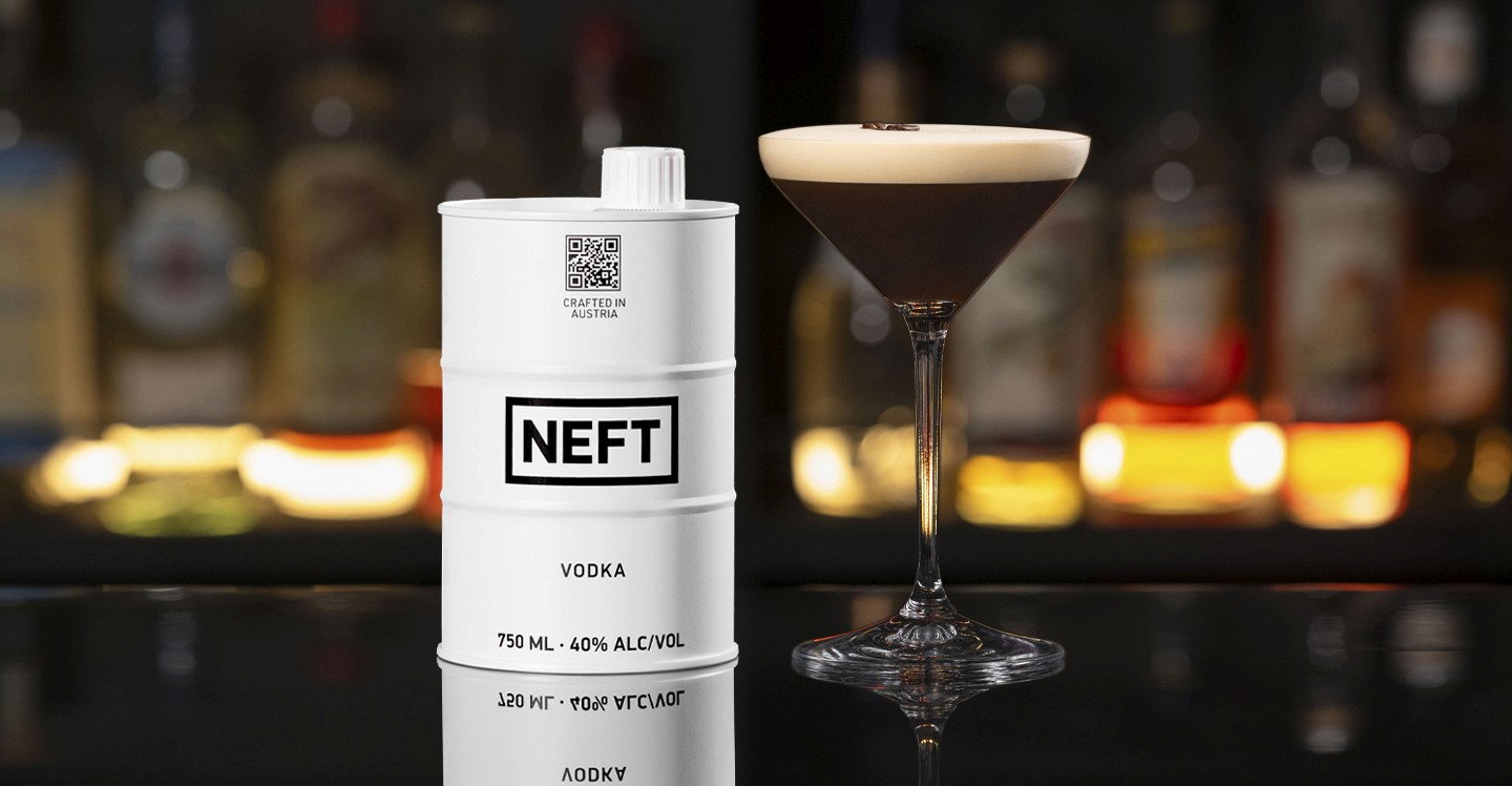 A NEFT Barrel and a glass of Espresso Martini  on a bar counter.