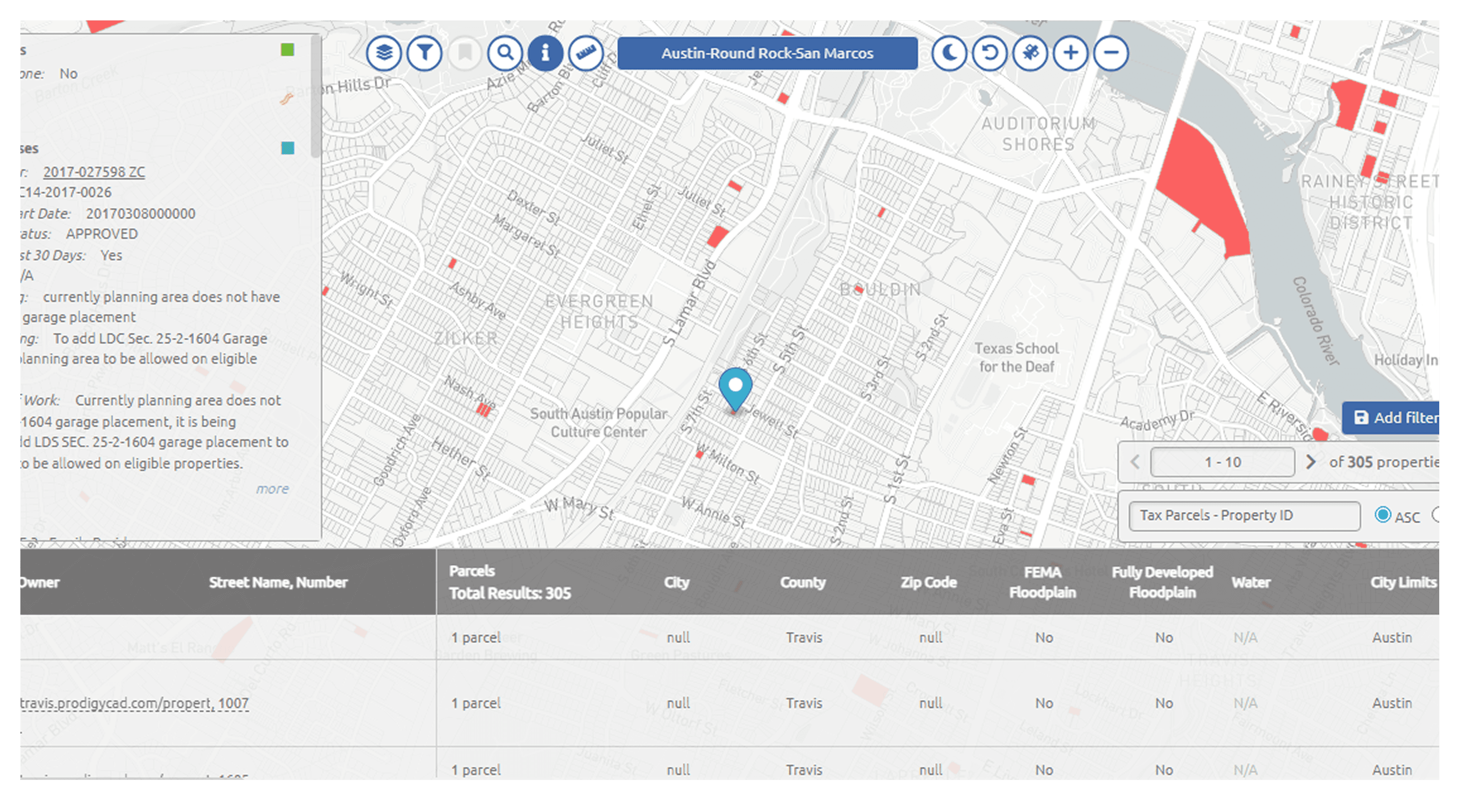 A large orange truck driving down a dirt road