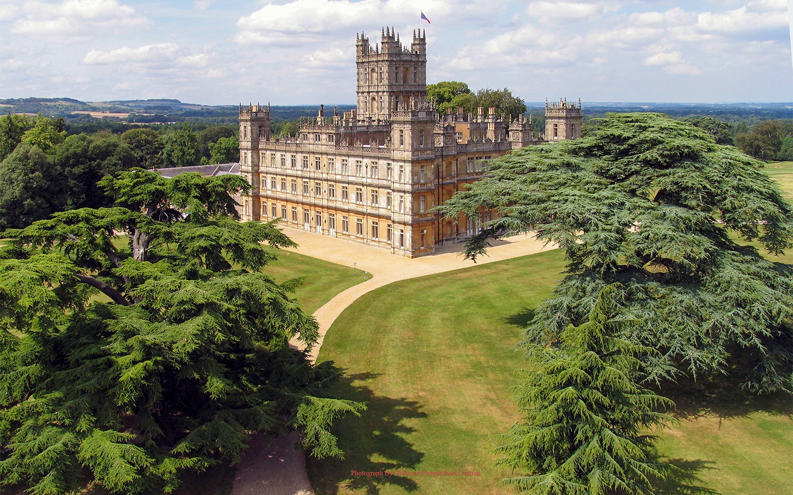 Highclere Castle surrounded by lush gardens, featured in Downton Abbey tours.