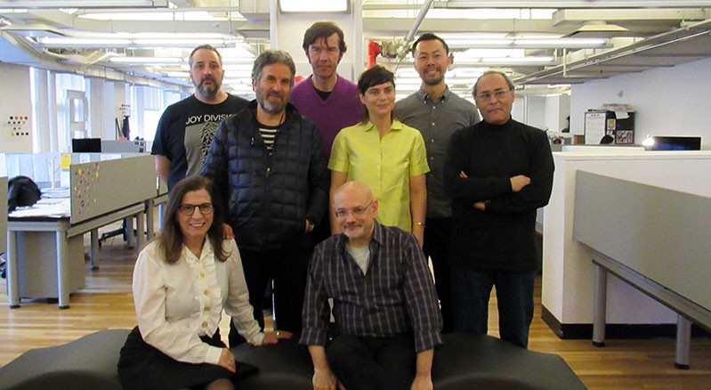 A photo of group of people standing in an office.