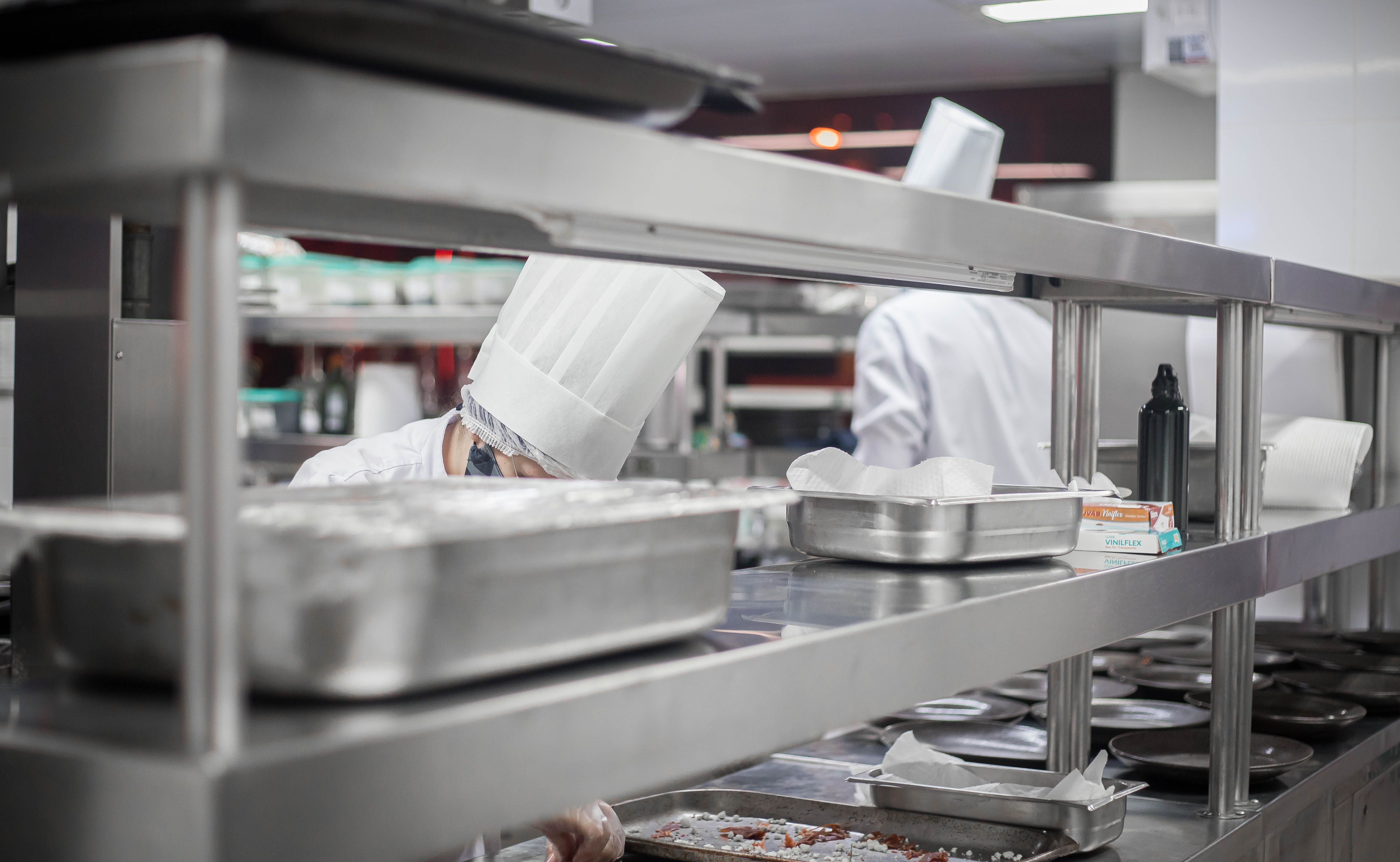 Chefs working diligently in a modern stainless steel kitchen, preparing delicious dishes.
