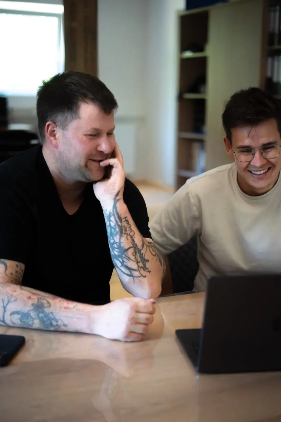 Persönliche Webdesign Beratung bei Studio Hansen: zwei Personen sitzen gemeinsam am Laptop und besprechen die neue Website, Webdesigner Nordfriesland