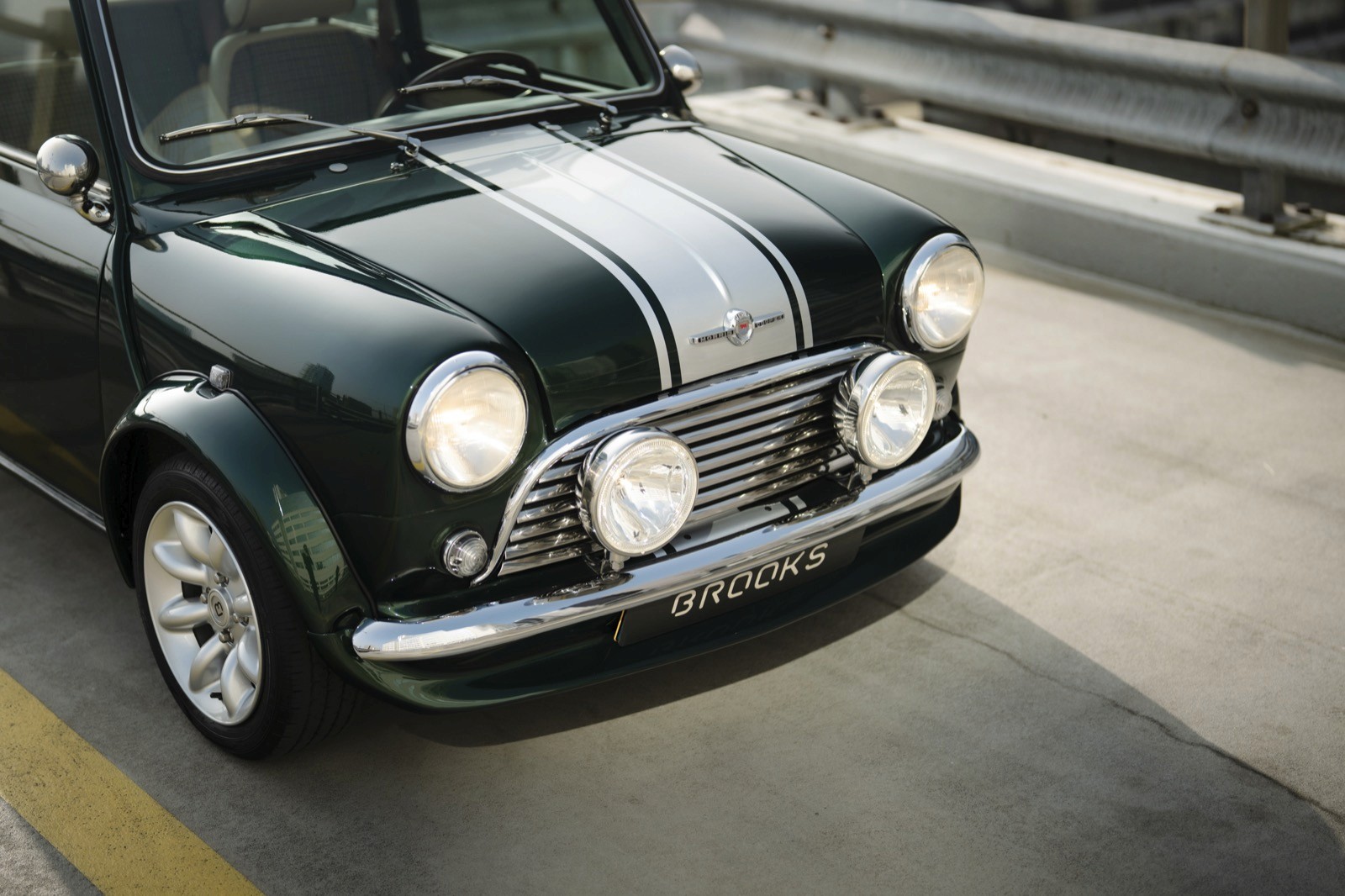 A close-up of a classic black car with a silver stripe, parked on a roadway.