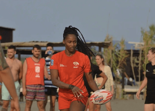 female rugby player on a beach