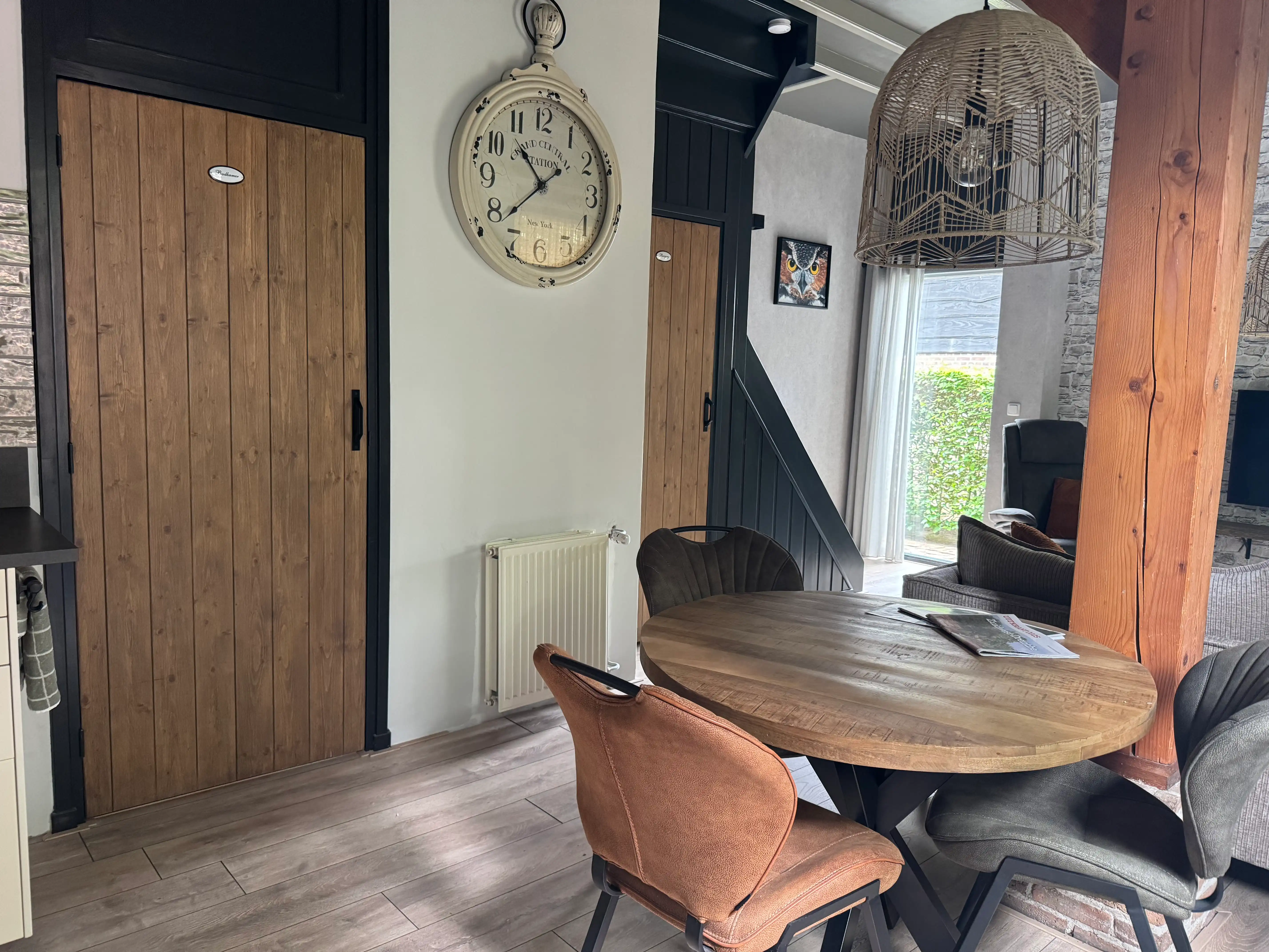 Donkere designtrap met trapmatten naast een houten schuifdeur.