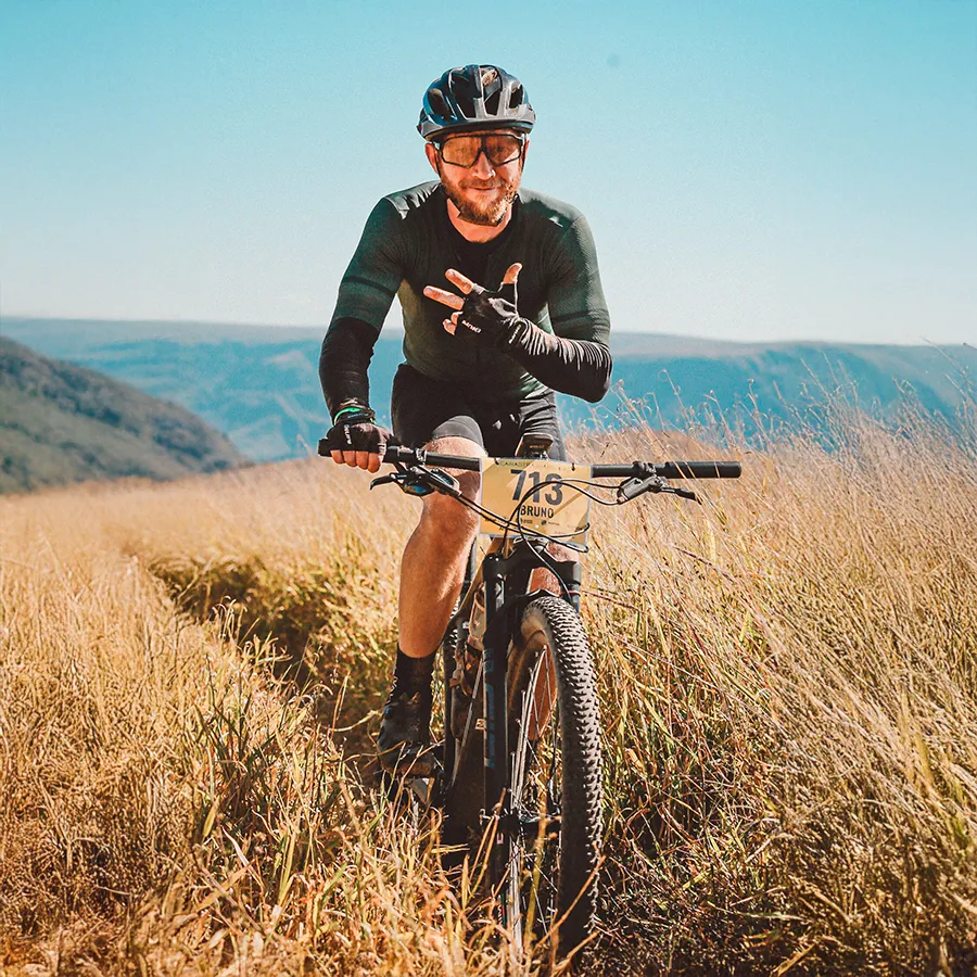 Homem sentado em ambiente escuro, sendo iluminado apenas pela luz da tela do celular.